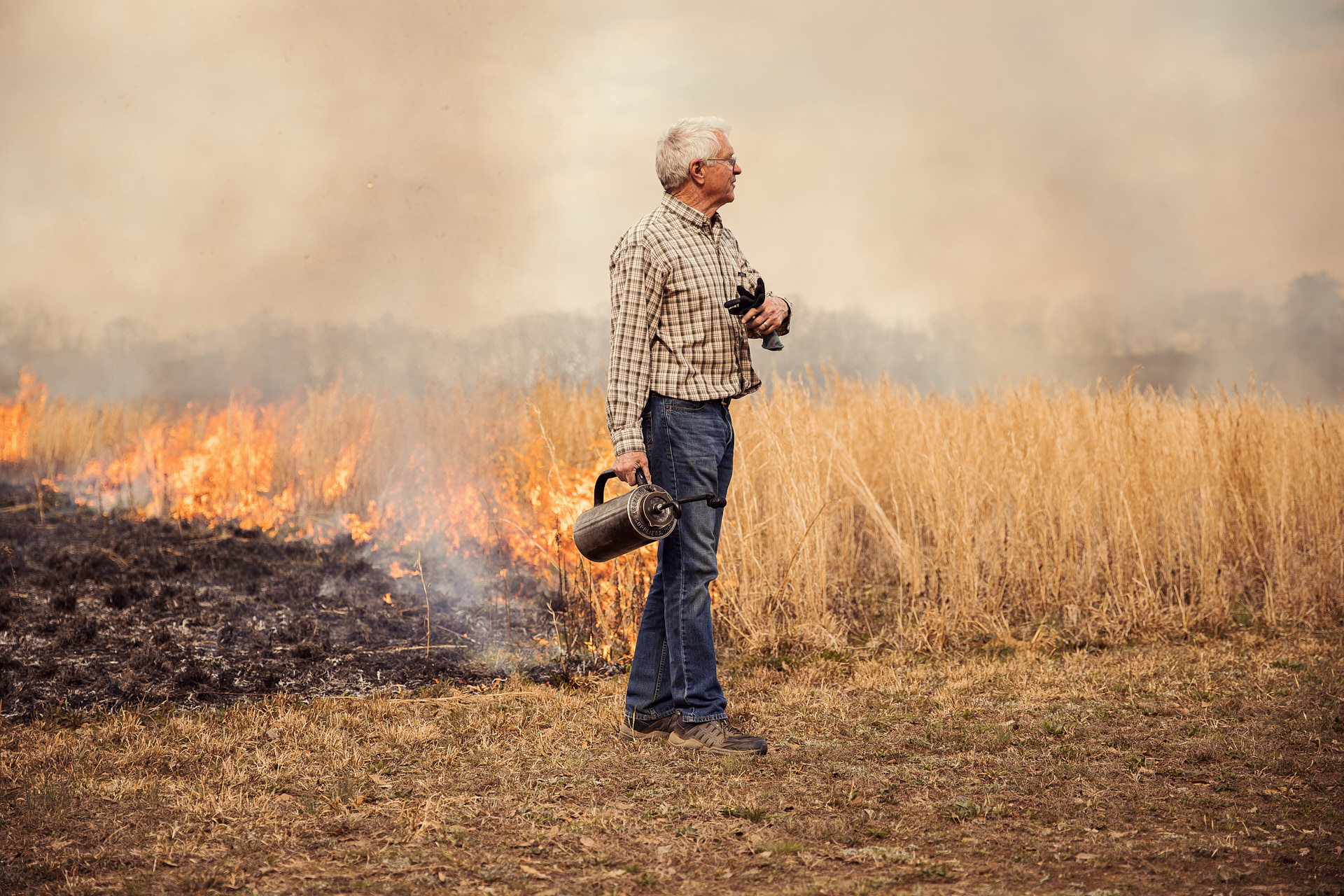 man stands in front of fire in field brandon clifton atlanta photographer